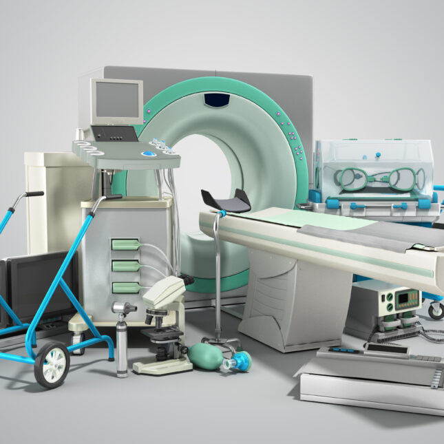 Medical devices, including an MRI scan machine, computers, otoscope, defibrillator, microscope, rollator, and more, against a grey background