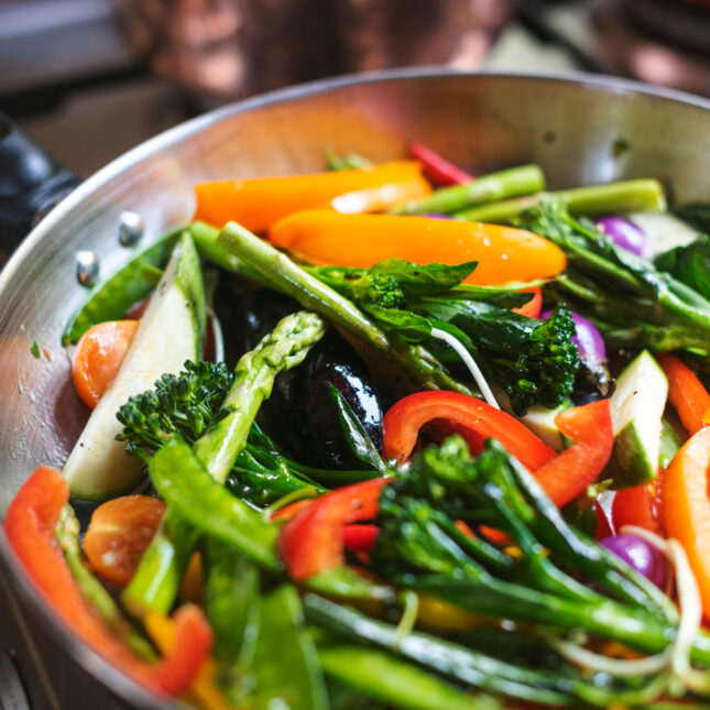 Photograph of a veggie medley in a pan on the stove.