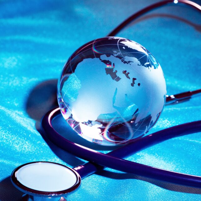 A glass globe circled by a stethoscope on a light blue shimmering fabric — first opinion coverage from STAT