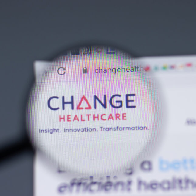 Change Healthcare logo, displayed on a screen, as seen through a magnifying glass — coverage from STAT