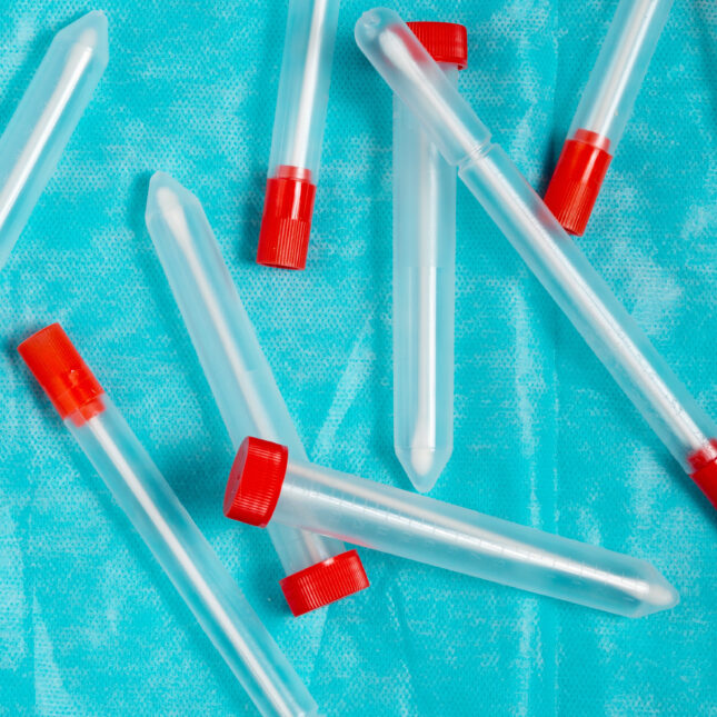 Photo illustration of Covid 19 testing swabs on a blue background.