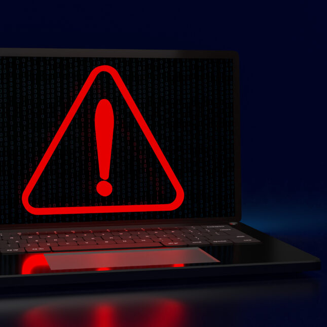A red warning sign pops up on a laptop screen filled with subtle binary codes — hospitals coverage from STAT