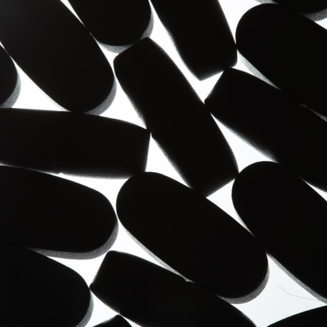 Multivitamin tablets are seen in silhouette