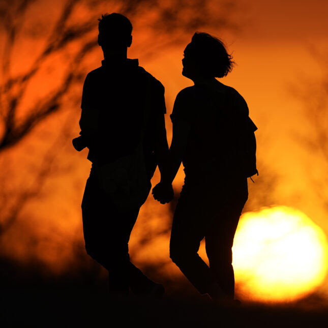 A couple walks through a park at sunset in Kansas City, Missouri.