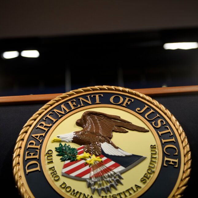 The logo of Department of Justice on a podium — coverage from STAT