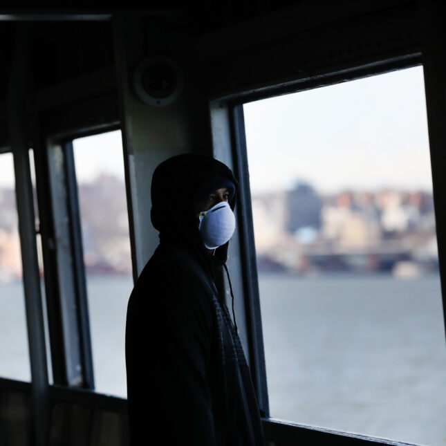 A masked person rides on an empty Staten Island Ferry — first opinion coverage from STAT