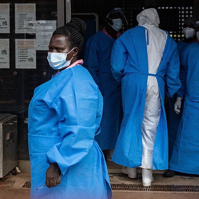 Members of the Ugandan Medical staff of the Ebola Treatment Unit stand inside the ward in Personal Protective Equipment (PPE) at Mubende Regional Referral Hospital in Uganda on September 24, 2022. - On September 20, 2022, the health authorities in Uganda declared an outbreak of Ebola after a case of the Sudan ebolavirus was confirmed in the Mubende district and registering three deaths including a 12-years-old girl.
