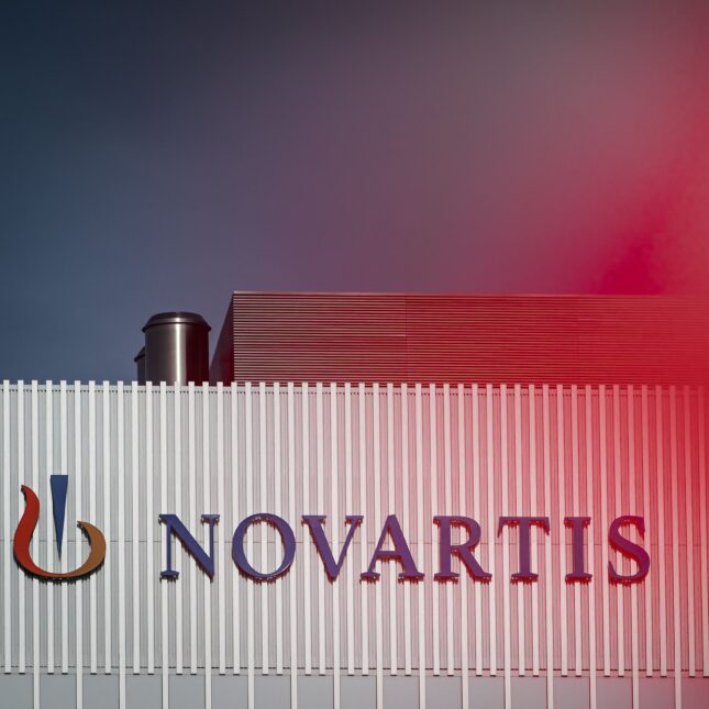 Logo of Novartis on a building next to a blur of red — biotech coverage from STAT