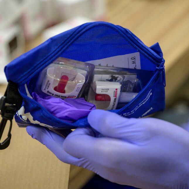 A staff member holds an overdose prevention kit, including Narcan nasal sprays used to treat narcotic overdoses in an emergency situation. -- health coverage from STAT