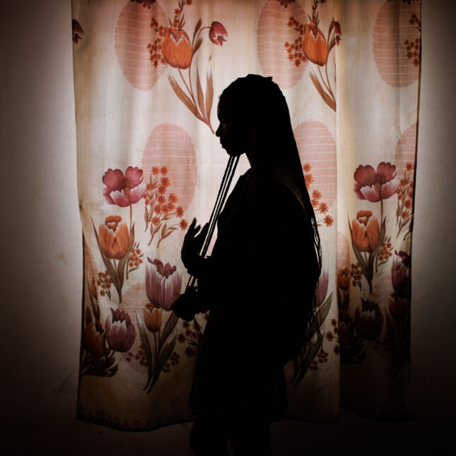The silhouette of a woman standing near a window. -- health coverage from STAT