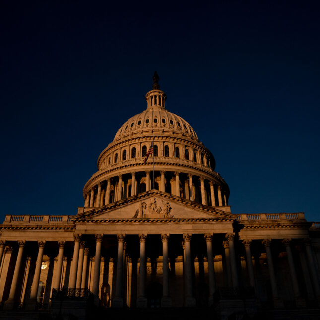 The front of the Capitol Hill, illuminated in dim yellow sunlight under dark blue sky — exclusive coverage from STAT