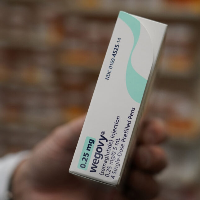 A pharmacist hands a box of Wegovy — first opinion coverage from STAT