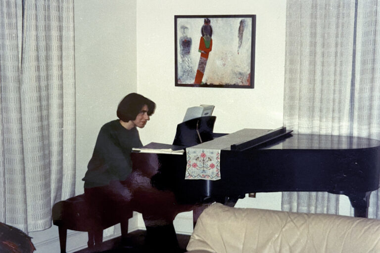 Tippi MacKenzie plays piano in her childhood home.